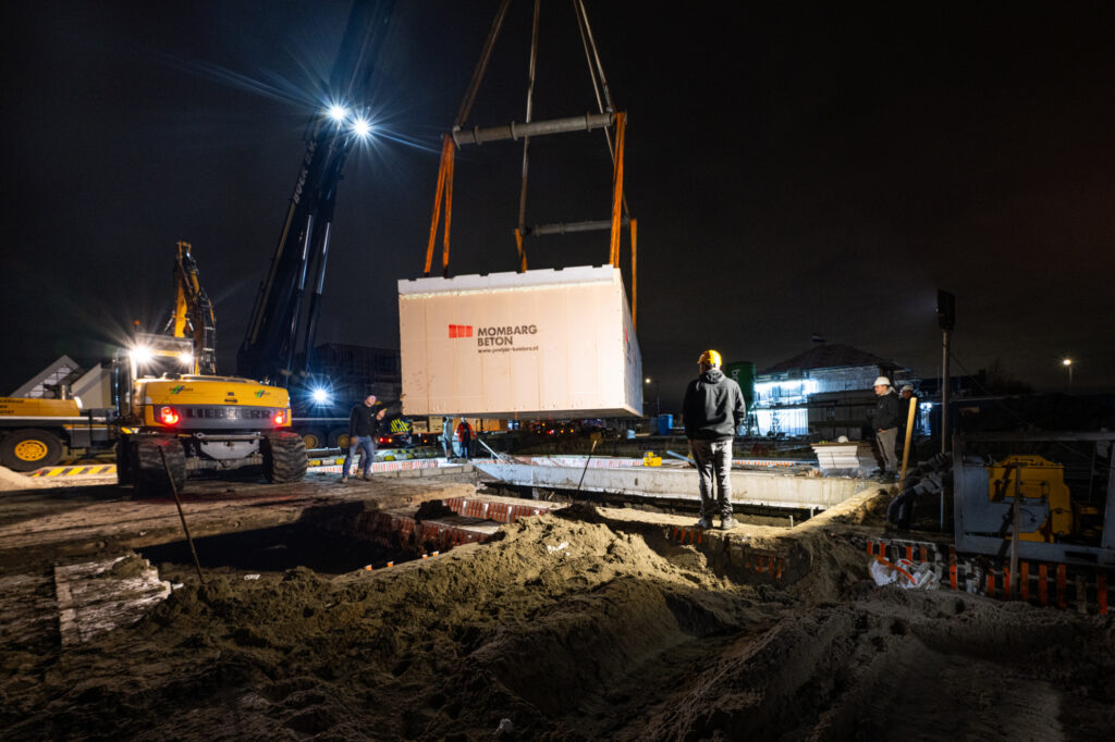 Prefab kelderbak wordt in de nacht geplaatst